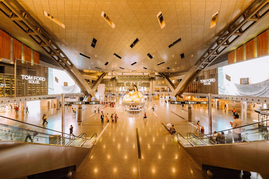 View of a spacious modern terminal interior with travelers and architectural features. Long Layover Tips