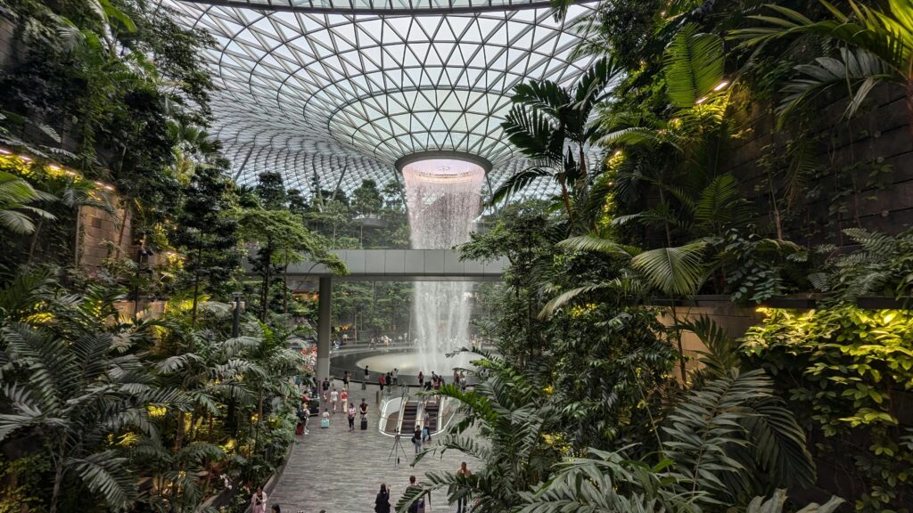 Explore the indoor waterfall and lush greenery of Jewel Changi Airport in Singapore.